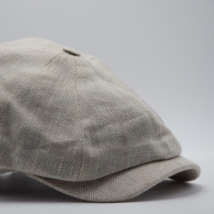 Närbild på ljusbeige fiskbensväv på Wigéns gubbkeps